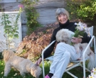 Barbara Norfleet '47, H'14 holding flowers and a dog.